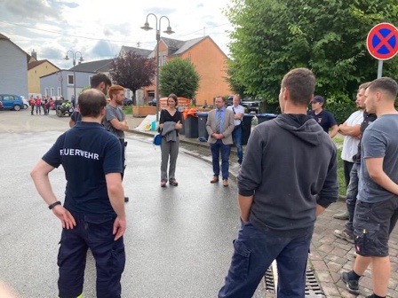Anne Spiegel steht in Ralingen zwischen Helfern der Flutkatastrophe